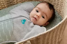 Baby in swaddle in bassinet